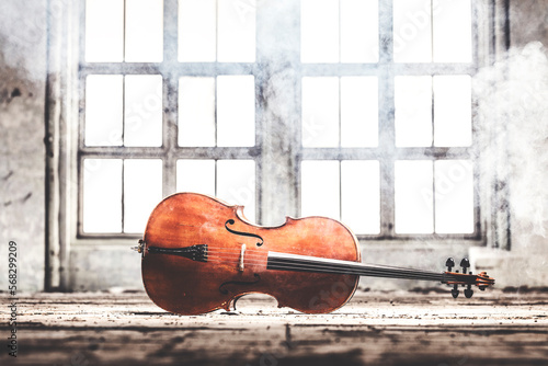 A cello on its side in an grunge industrial environment with smoke in the air