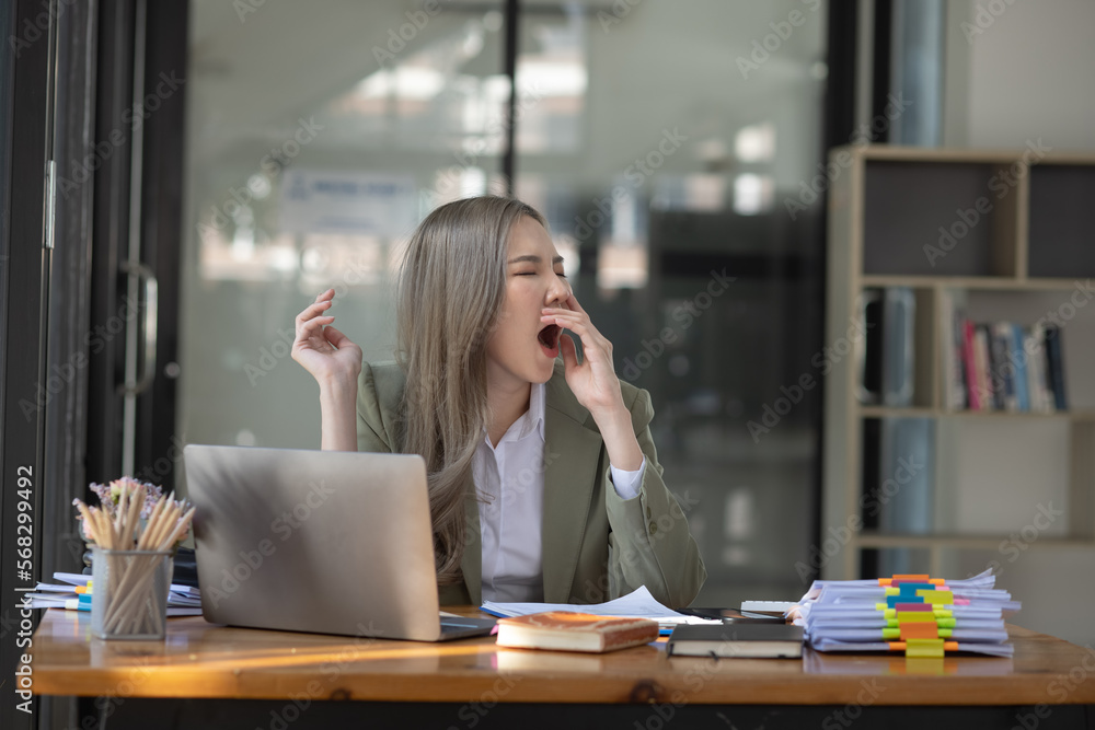 Asian businesswoman are stressed and tired from work sitting at desk in the office, feeling sick at work, stress from work. Asian businesswoman are stressed and tired from work sitting at desk in the office, feeling sick at work, stress from work.