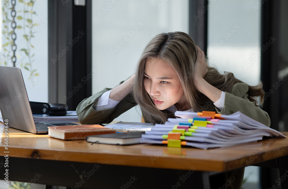Asian businesswoman are stressed and tired from work sitting at desk in the office, feeling sick at work, stress from work. Asian businesswoman are stressed and tired from work sitting at desk in the office, feeling sick at work, stress from work.