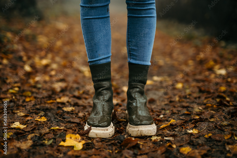 Female footwear boots standing in the forest path covered with earth and leaves. Female footwear boots standing in the forest path covered with earth and leaves.