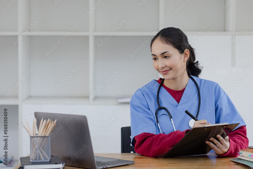 Happy smiling doctor woman working on laptop at desk in hospital, Professional doctor medical and healthcare. Happy smiling doctor woman working on laptop at desk in hospital, Professional doctor medical and healthcare.
