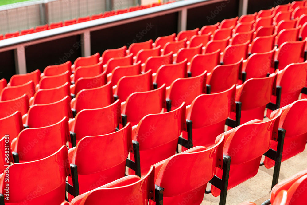 Fototapeta premium red plastic chair in football, basketball or baseball arena stadium in a row for visitor to visit and enjoy sport match competition for big football match in football stadium