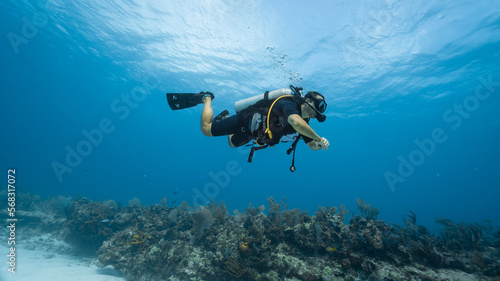 Scuba diver practicing buoyancy near coral reef