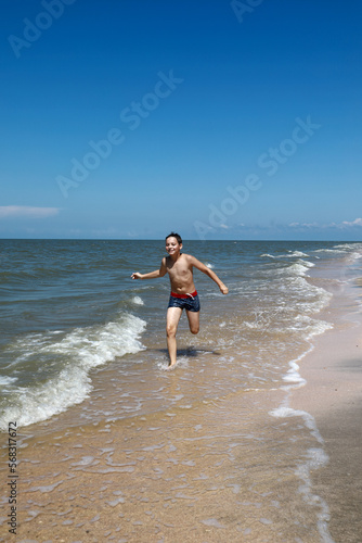 Child running along beach of Sea of Azov