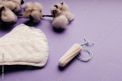 Woman hygiene protection and menstruation concept. Sanitary pads and cotton on purple background close-up