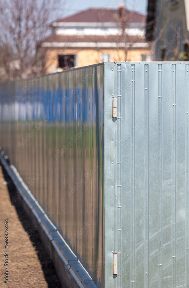 Metal galvanized fence on the site near the house