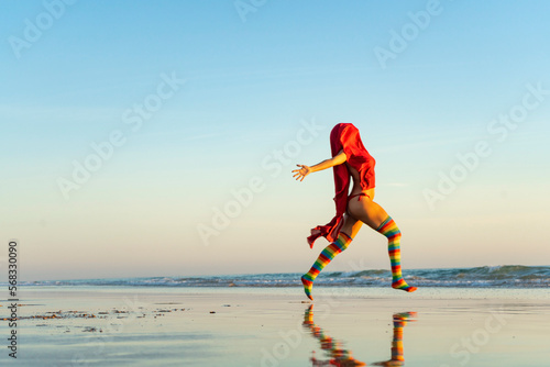 girl running free to the sea in rainbow tights photo