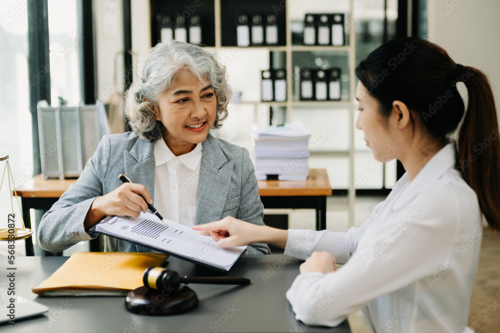 Asian business team and lawyers discussing contract papers sitting at the table. Concepts of law, advice, legal services. at office Asian business team and lawyers discussing contract papers sitting at the table. Concepts of law, advice, legal services. at office