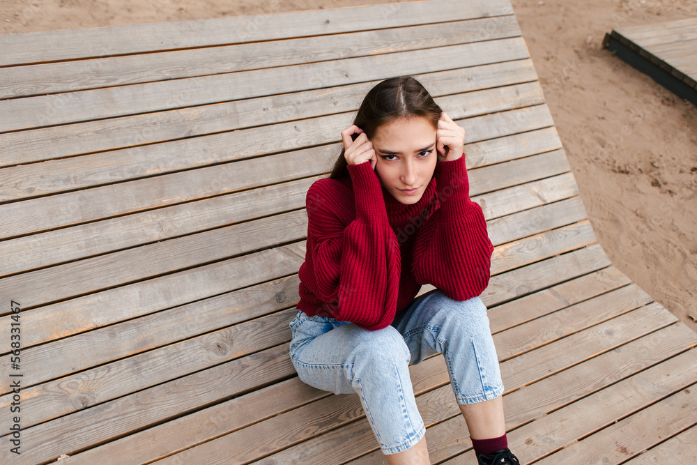 Young asian beautiful girl sitting on the wooden bench Young asian beautiful girl sitting on the wooden bench