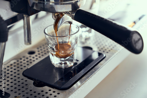 A single espresso shot being pulled from an espresso machine. photo