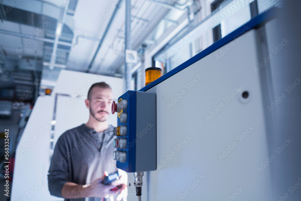 Young male engineer examining control panel with multimeter in an industrial plant, Freiburg im Breisgau, Baden-Württemberg, Germany Young male engineer examining control panel with multimeter in an industrial plant, Freiburg im Breisgau, Baden-Württemberg, Germany