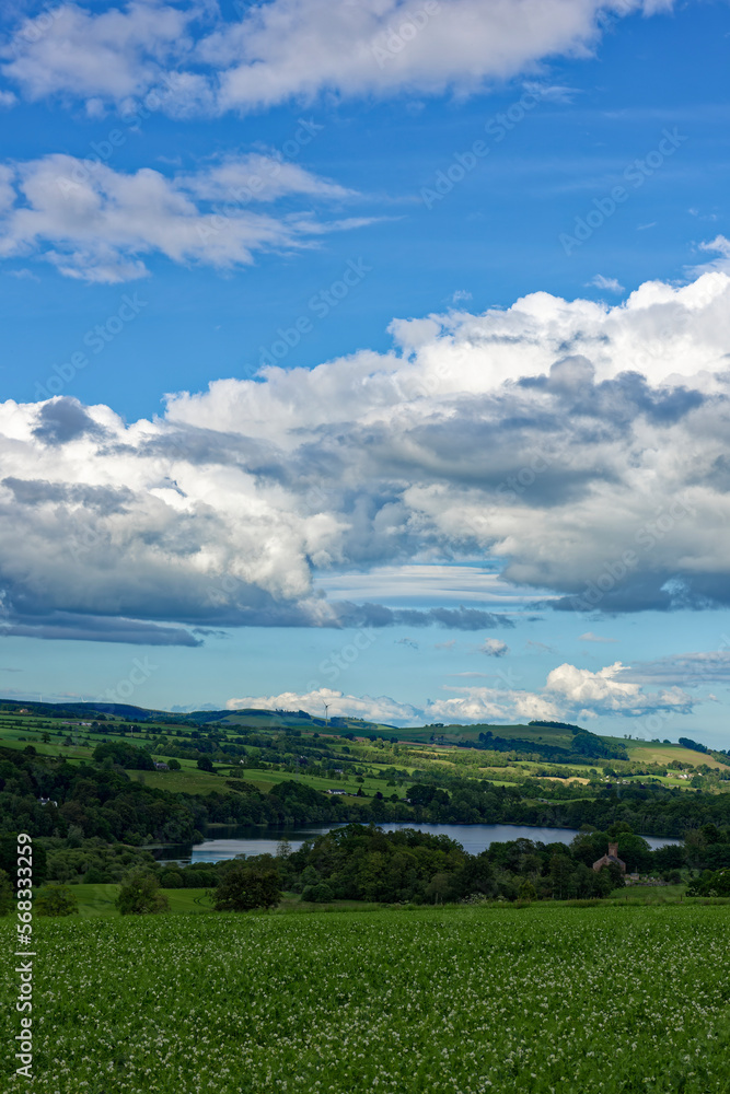 Looking down to Loch Clunie from the surrounding Hills with scattered Trees amongst the farmland of the surrounding Hills.