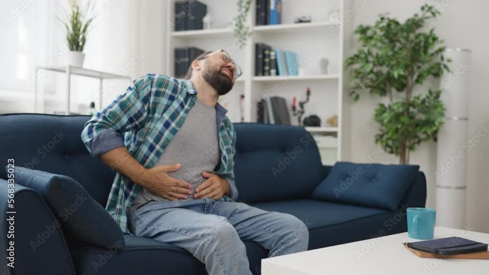 Middle-aged man suffering from stomach ache at home, severe food poisoning Middle-aged man suffering from stomach ache at home, severe food poisoning