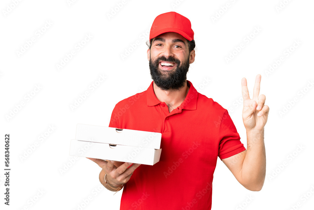 Pizza delivery man with work uniform picking up pizza boxes over isolated chroma key background smiling and showing victory sign Pizza delivery man with work uniform picking up pizza boxes over isolated chroma key background smiling and showing victory sign