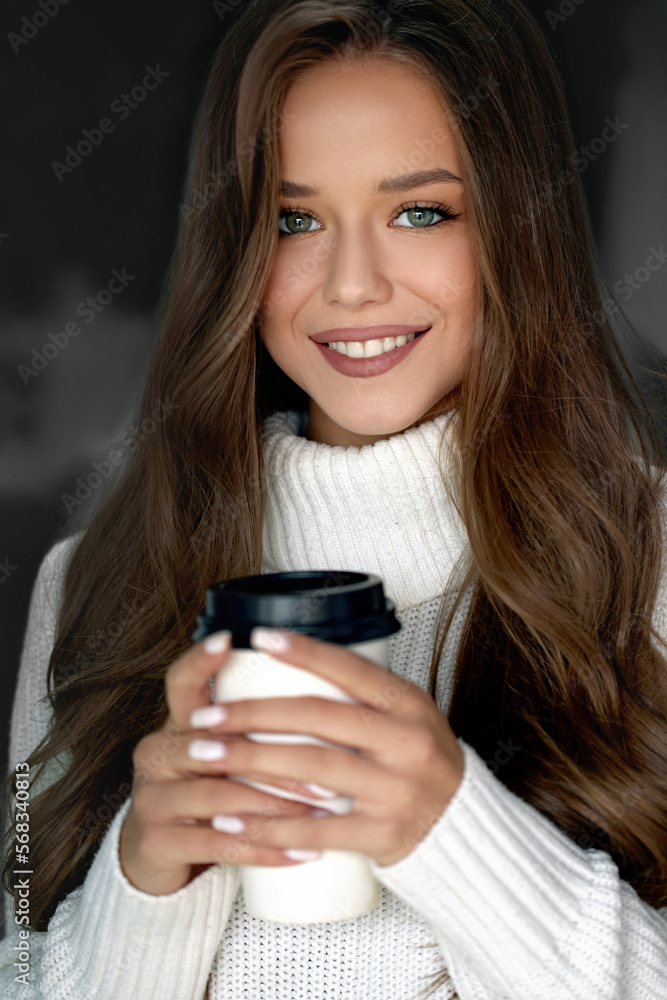 Beautiful woman drinking coffee. Girl holds paper cup of hot latte Beautiful woman drinking coffee. Girl holds paper cup of hot latte