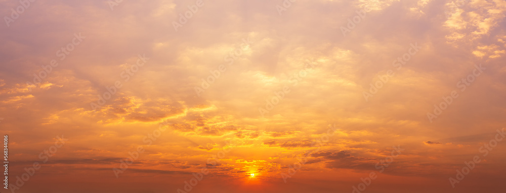 Photos of the sky at sunset or sunrise. Fluffy clouds covered the sky and Sun shine, panoramic image. Orange tones, natural phenomenon background.