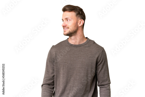 Young handsome caucasian man over isolated chroma key background looking to the side and smiling