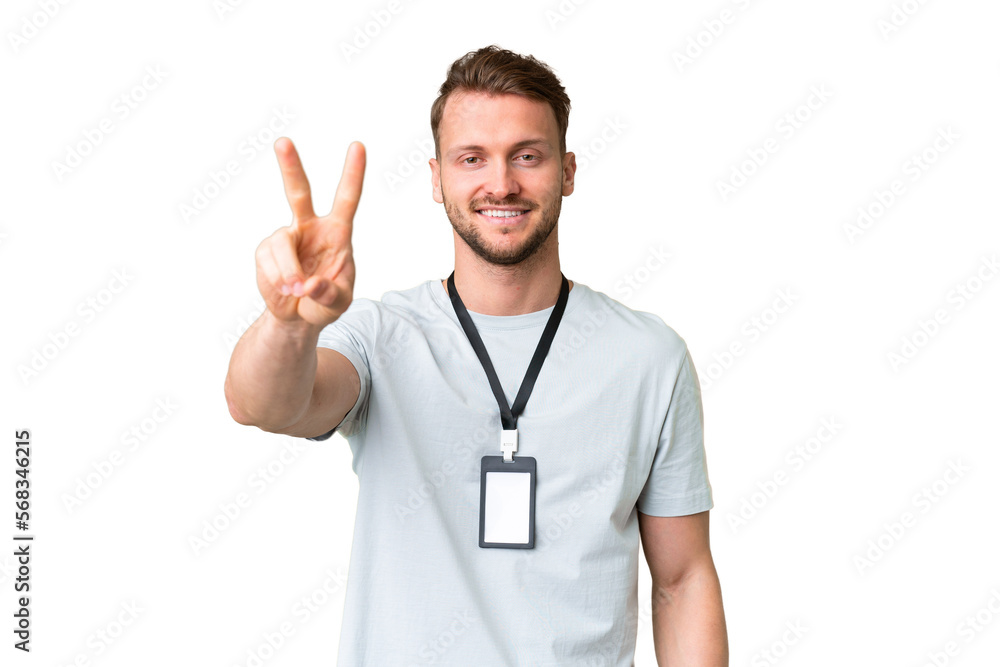 Young caucasian man with ID card over isolated chroma key background smiling and showing victory sign Young caucasian man with ID card over isolated chroma key background smiling and showing victory sign