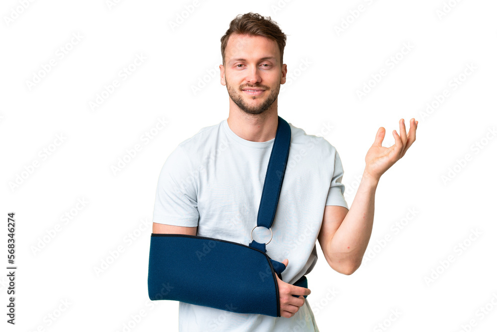 Young caucasian man with broken arm and wearing a sling over isolated chroma key background extending hands to the side for inviting to come Young caucasian man with broken arm and wearing a sling over isolated chroma key background extending hands to the side for inviting to come
