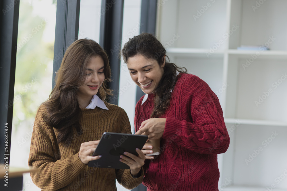 couple two woman looking at digital tablet in office. couple two woman looking at digital tablet in office.
