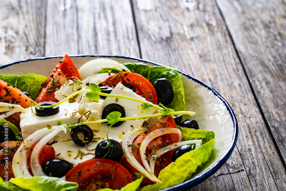 Fresh vegetable salad with feta cheese on wooden table
Fresh vegetable salad with feta cheese on wooden table