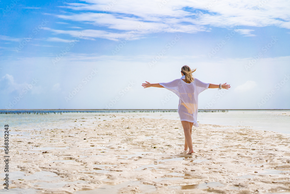 Beach holiday - woman walking on sunny, tropical beach during water outflow
Beach holiday - woman walking on sunny, tropical beach during water outflow
