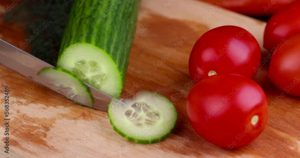 Cut the green long warm cucumber into pieces , cut the green cucumber into pieces with a sharp knife Cut the green long warm cucumber into pieces , cut the green cucumber into pieces with a sharp knife