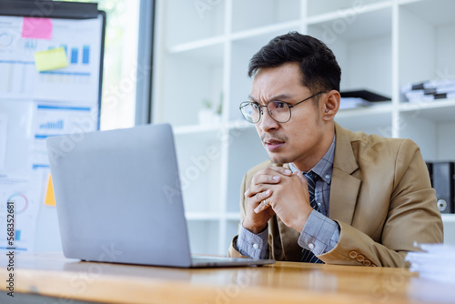 Stressed and sad Asian man sitting at desk in office, freelance business, Asian man emotion feelings, sad upset face.