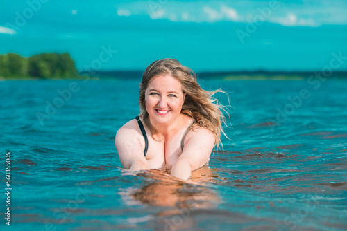 Plus size woman in water in swimsuit. Chubby nice lady  body positive concept  different women sizes