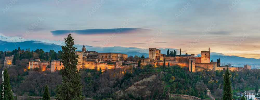 Panoramic of the Alhambra and the Palace of Carlos V with its artificial lighting at sunset, Granada.