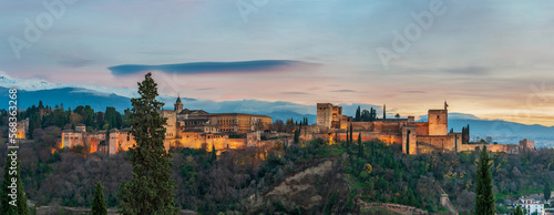 Panoramic of the Alhambra and the Palace of Carlos V with its artificial lighting at sunset, Granada.