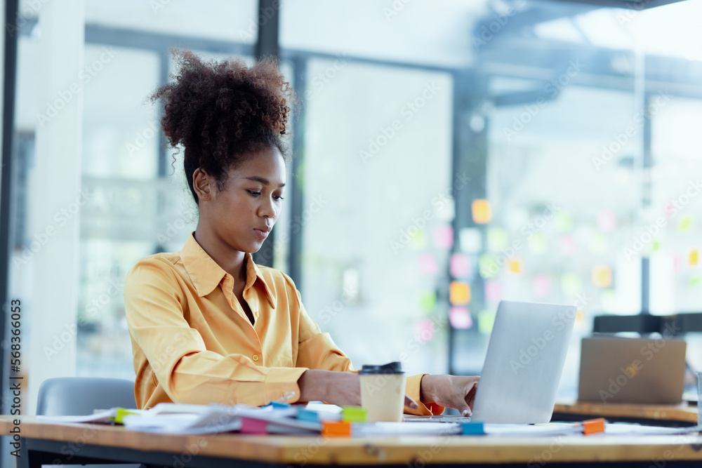 Young African American businesswoman working with pile of documents at office workplace, business finance and accounting concepts. Young African American businesswoman working with pile of documents at office workplace, business finance and accounting concepts.
