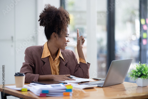 Young African American businesswoman working with pile of documents at office workplace, business finance and accounting concepts.