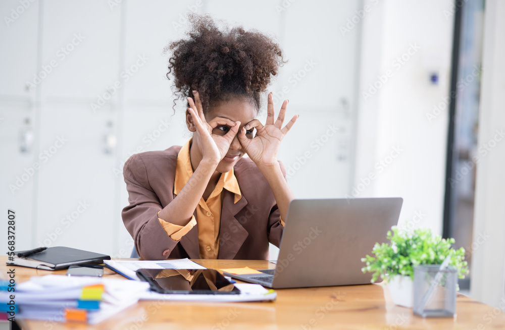 Young African American businesswoman working with pile of documents at office workplace, business finance and accounting concepts. Young African American businesswoman working with pile of documents at office workplace, business finance and accounting concepts.