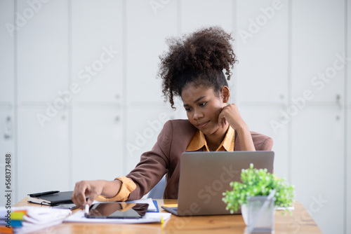 Young African American businesswoman working with pile of documents at office workplace, feeling sick at work, stress from work, overworked, problem, unhappy. 