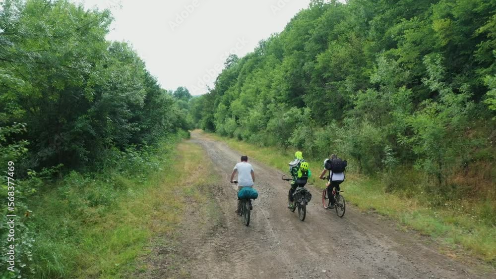 Group of cyclists team ride down gravel mountain road in national park or forest. Friends on bikes ride together have fun outdoors. Aerial drone shot of senior cyclists ride beautiful landscape Group of cyclists team ride down gravel mountain road in national park or forest. Friends on bikes ride together have fun outdoors. Aerial drone shot of senior cyclists ride beautiful landscape
