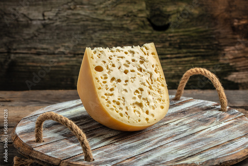 French emmental semi-hard cheese with big holes on a wooden background. farmer market. top view. place for text