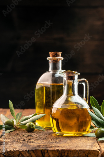 olives and oil. extra virgin olive oil jars on a wooden background. vertical image. place for text