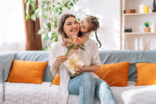 Daughter hugged her mother and gave a gift and flowers. mother's day