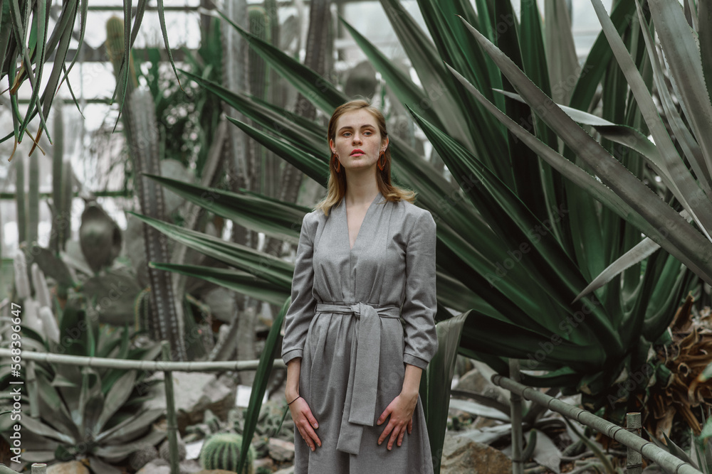 A girl poses in a botanical garden among plants A girl poses in a botanical garden among plants