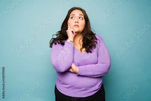 Creative obese woman thinking of a new idea photo