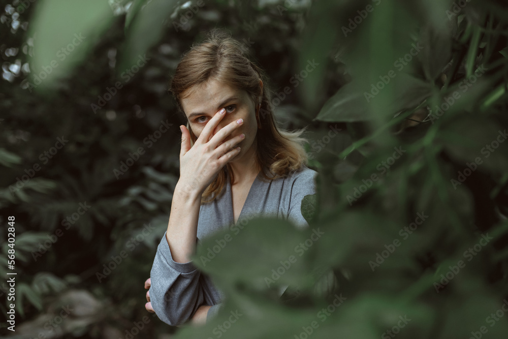 A girl poses in a botanical garden among plants A girl poses in a botanical garden among plants