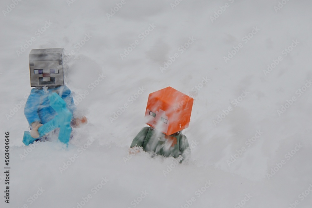 Fototapeta premium LEGO Minecraft figures of Steve with diamond sword and Alex under stream of snow in mountain avalanche.