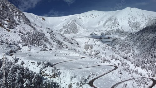 Vallter 2000 ski resort. Aerial winter landscape with a very winding road. Setcases, Ripollés, Girona Pyrenees, Catalonia. Vacations, travel, nature and tourism concept. 4k drone video.