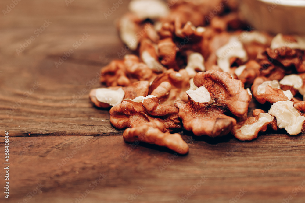 Dried walnut grains scattered on a wooden table. Dried walnut grains scattered on a wooden table.