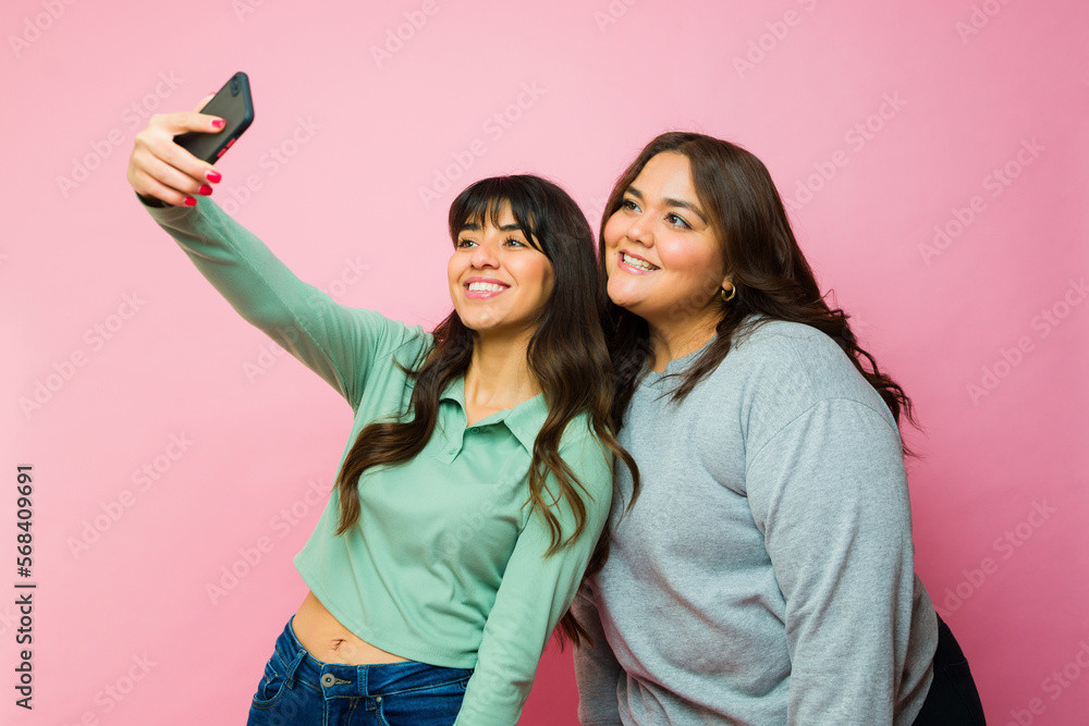 Cheerful best friends taking selfies together Cheerful best friends taking selfies together