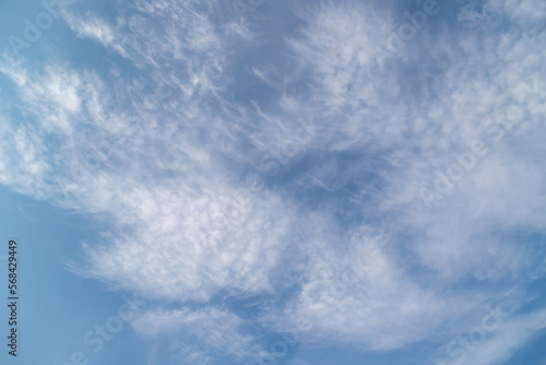 Sunny weather with cumulus and cirrus clouds on blue sky.