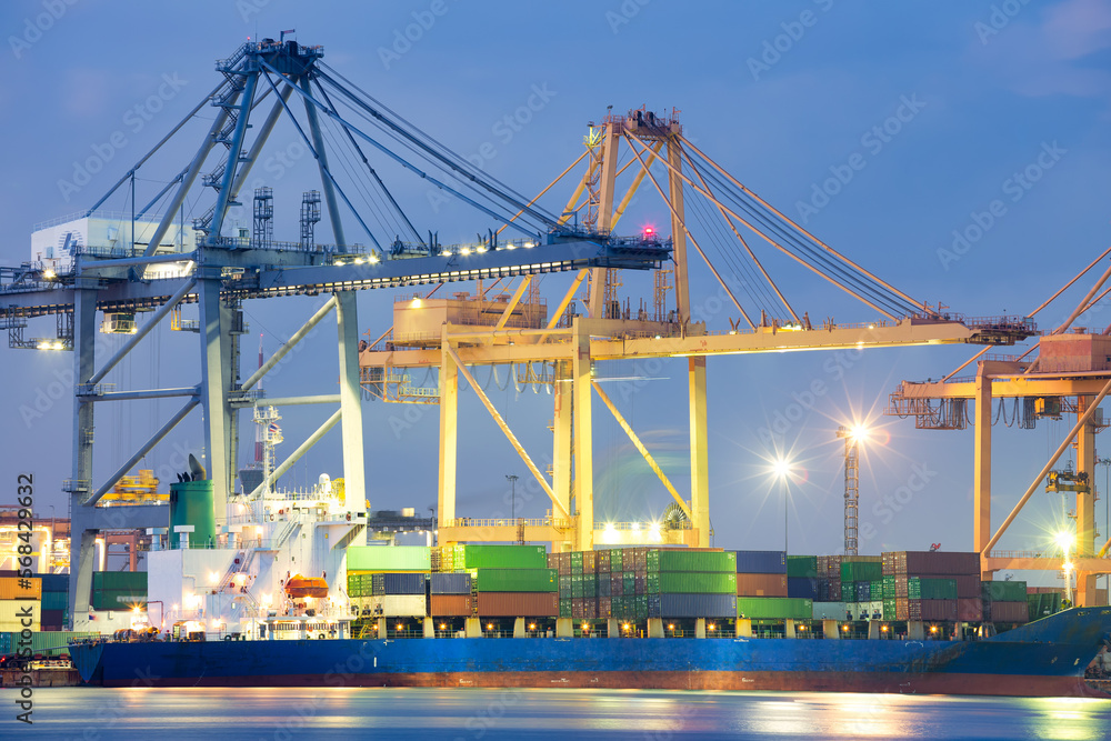 Cargo ship at dock, port or harbor. To loading cargo container, work with crane. Concept of business and industry i.e. shipping, logistics, international trade, freight transport and import export.