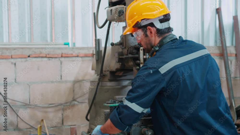 Young caucasian engineer man operating lathe machine for preparing production at factory industrial, technician or labor maintenance machinery at workplace, metalworker working, industry concept.
