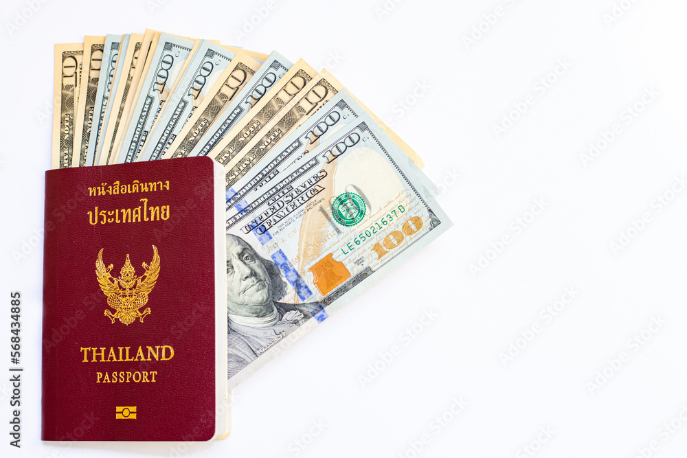 Passport of Thailand and group of money dollars banknotes arranged on white background and space for text. Exchange money, money, cash, finances concept. Travel and immigration concept. Passport of Thailand and group of money dollars banknotes arranged on white background and space for text. Exchange money, money, cash, finances concept. Travel and immigration concept.